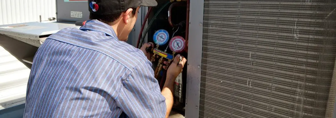 HVAC technician servicing a condenser unit in Creswell