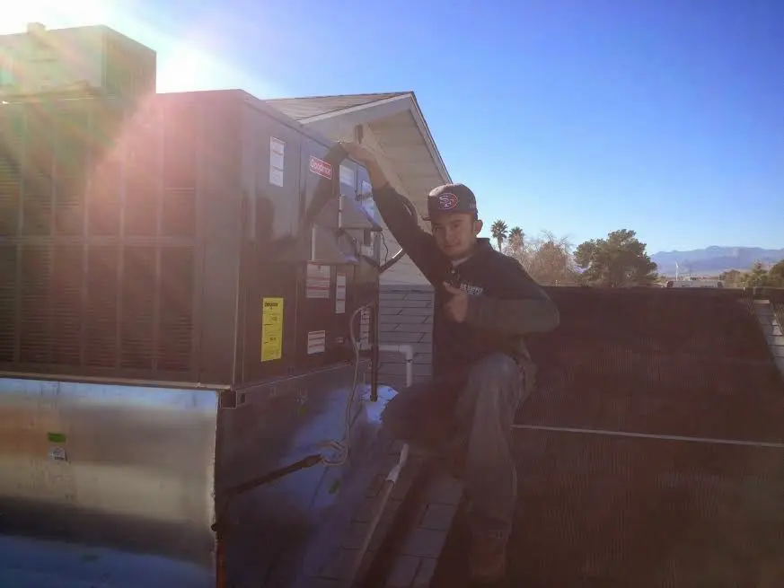 HVAC technician performing Air Duct Cleaning on a rooftop unit in Creswell
